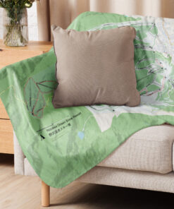 Nozawa Onsen ski map blanket draped over sofa with cushion – cozy home decor for skiers